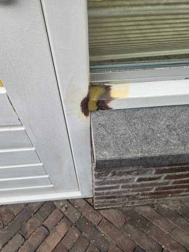 Roestige plek op een deur met een gele en bruine verkleuring